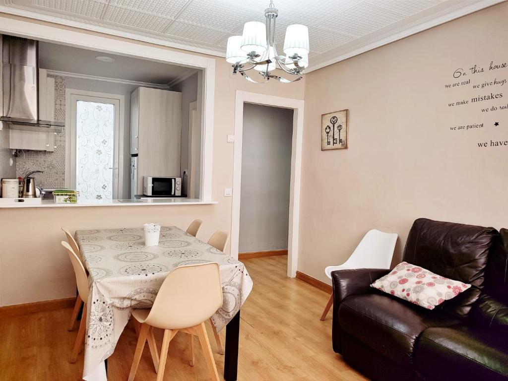 ein Wohnzimmer mit einem Tisch und einem Sofa in der Unterkunft Serendipia Apartamentos 1 in Logroño