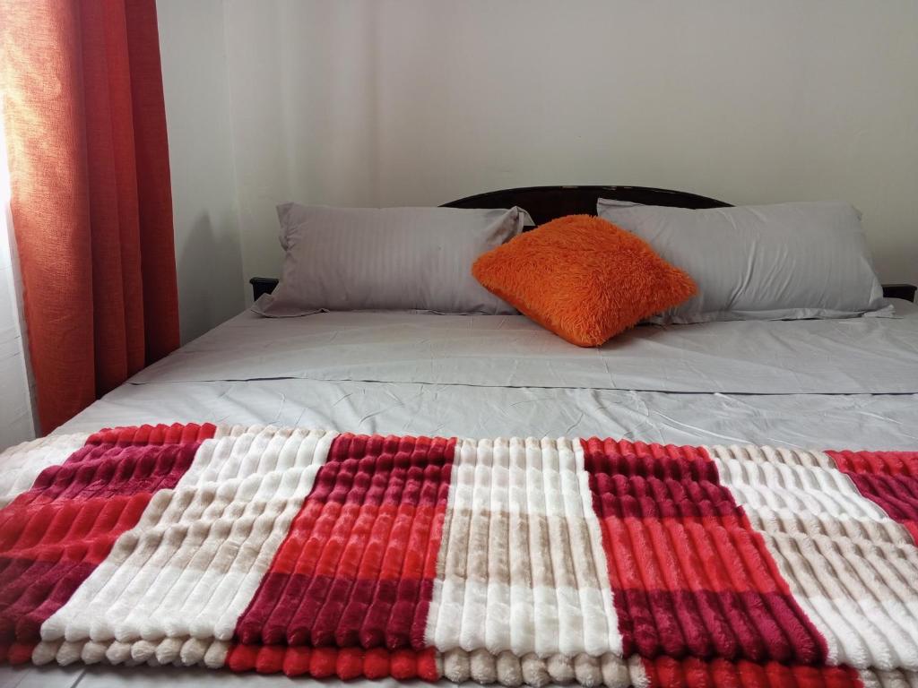 a bed with a red and white blanket on it at COZY COTTAGE® 