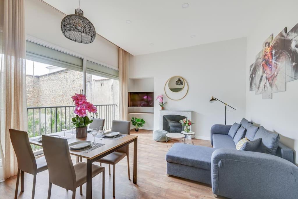 un salon avec un canapé bleu et une table dans l'établissement BRP Cannes Center, Four-Bedroom Deluxe Apartment, à Cannes