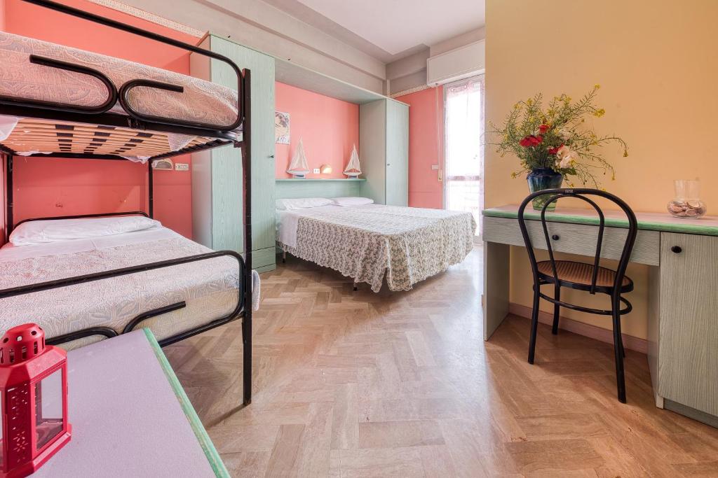 a room with two bunk beds and a table at Hotel Sabbia d'Oro in Rimini