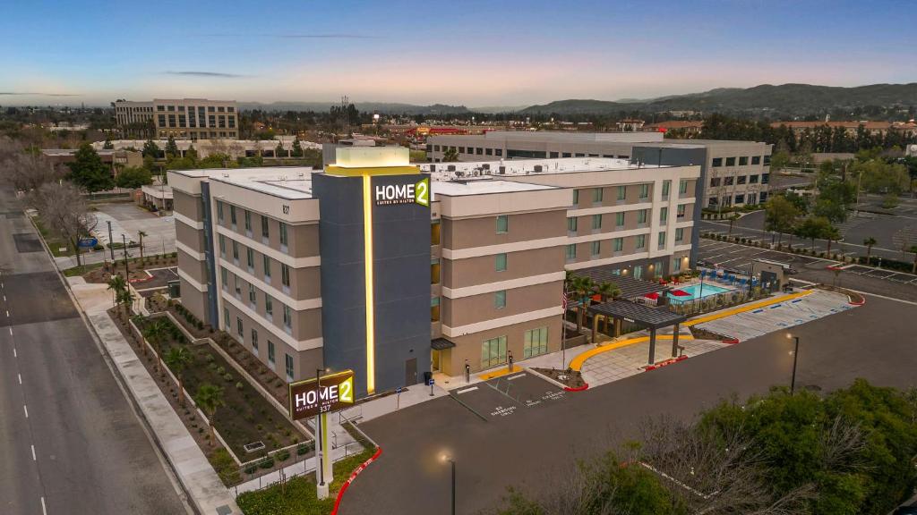 an aerial view of a building with a parking lot at Home2 Suites By Hilton San Bernardino in San Bernardino