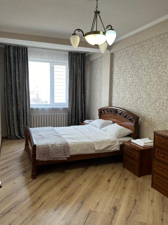 a bedroom with a large bed and a window at guest house djal in Bishkek