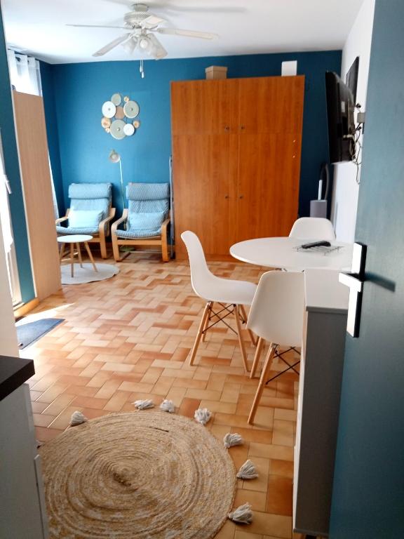un salon avec une table et des chaises et des coquillages au sol dans l'établissement Studio rénové vue montagne, à Amélie-les-Bains-Palalda