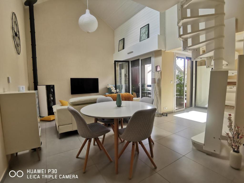 una sala de estar con una mesa y sillas en thierry, en Saint-Jorioz