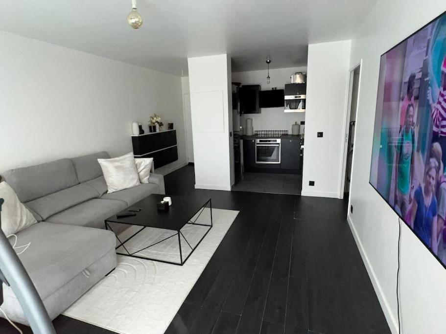 a living room with a couch and a table at Superbe T2, Paris, Stade de France, WIFI, Parking in Saint-Denis
