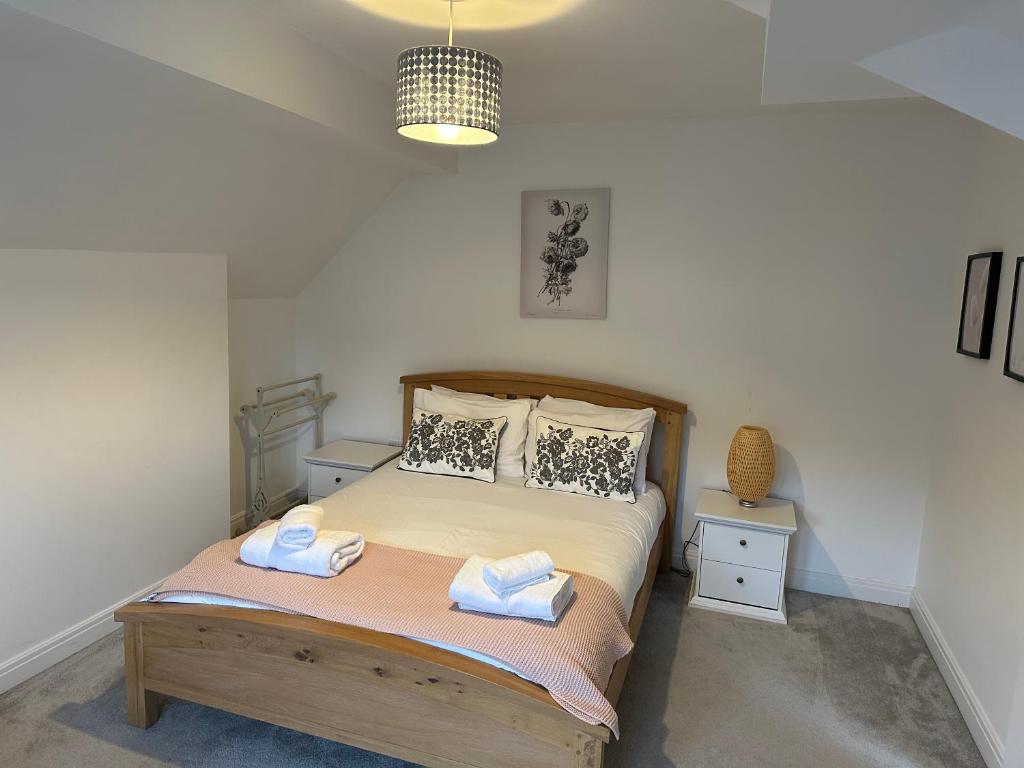 1 dormitorio con 1 cama con 2 toallas en King’s Road Apartments en Harrogate