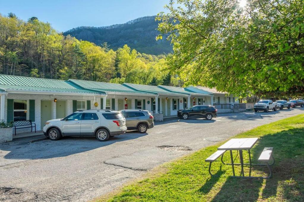 a row of cars parked in front of a motel at Geneva Hotel & Tiki Bar in Lake Lure