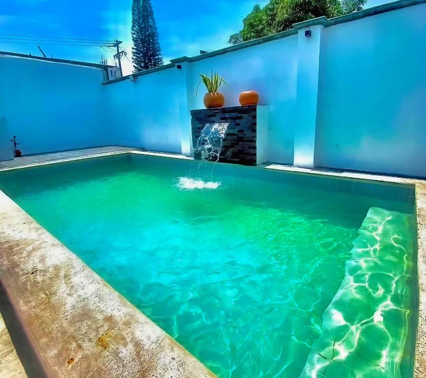 una piscina nel cortile di una casa con pareti blu di Casa los Abuelos a Xalapa