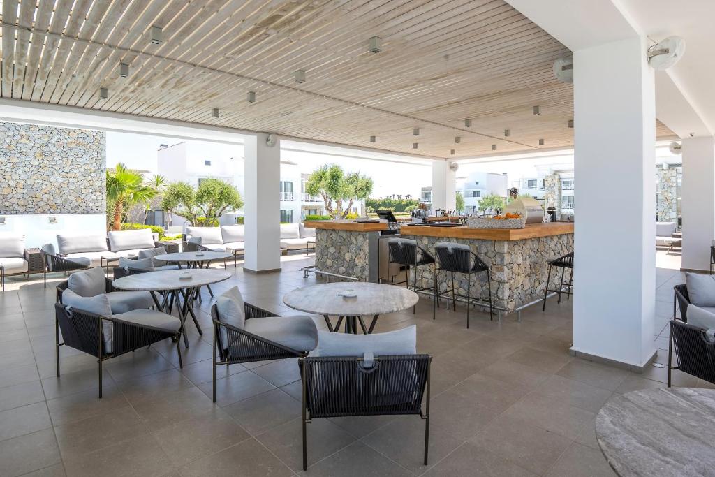 een restaurant met tafels en stoelen en een bar bij Diamond Deluxe Hotel - Adults Only in Kos-stad