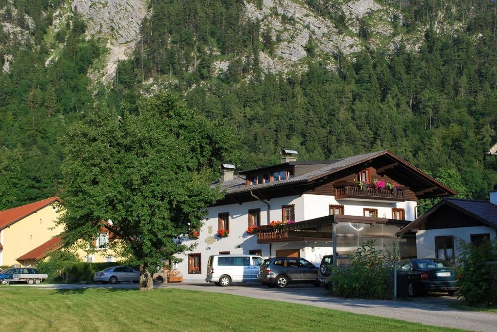 a building with cars parked in a parking lot at Gästehaus Riki Oberschmid in Steinbach am Attersee