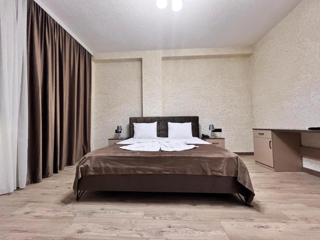 um quarto com uma cama e uma televisão em Avrasya Hotel em Baku