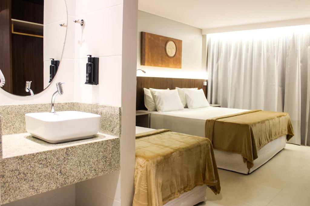 a hotel room with a bed and a sink at Smart Hotel João Pessoa in João Pessoa