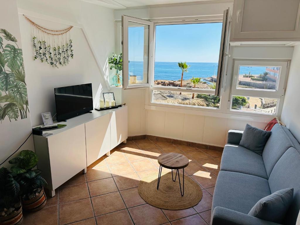 - un salon avec un canapé bleu et une vue sur l'océan dans l'établissement Apartament Cabo Cervera Costa del Alba, à Torrevieja