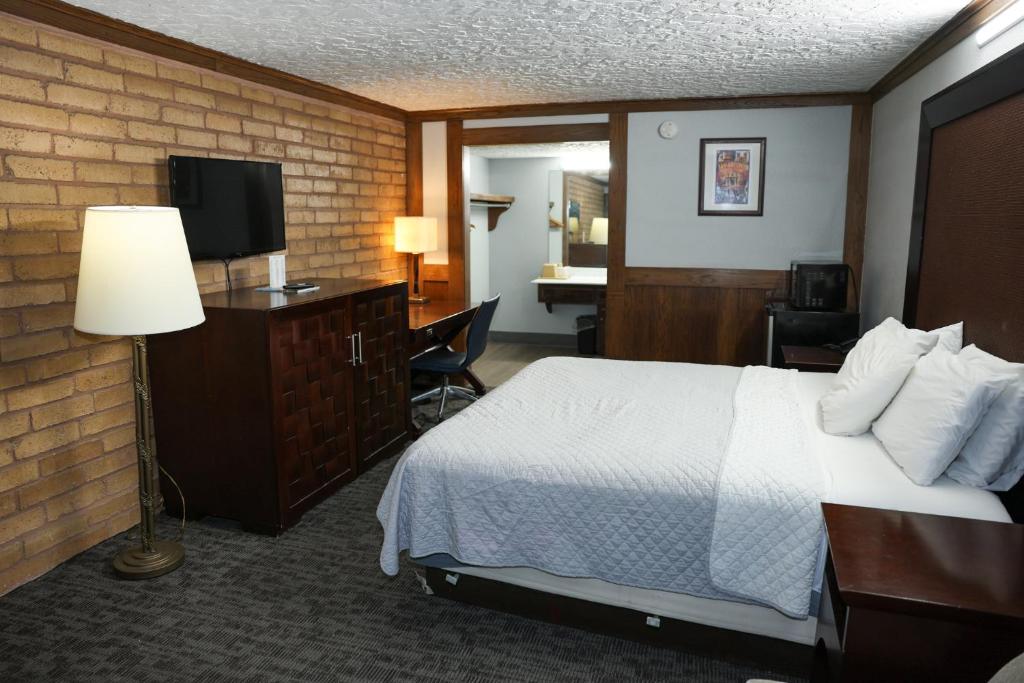 una habitación de hotel con una cama y un televisor en Rittiman Inn and Suites, en San Antonio