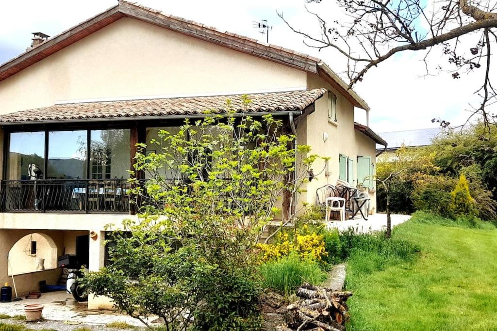 a house with a balcony and a yard at Ma Maison de Campagne in Le Brusquet