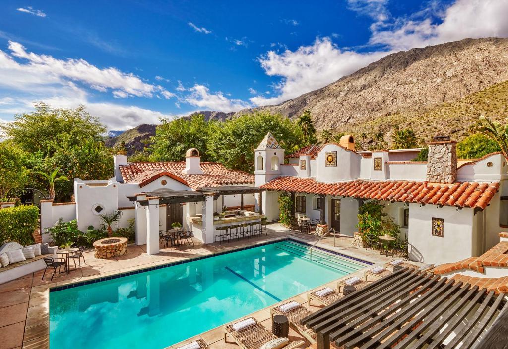 a house with a swimming pool and a mountain at Lucille Palm Springs in Palm Springs
