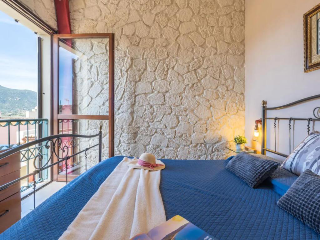 una camera con letto blu e balcone di I Borghi di Michele - Il nido di Mennenne a Villasimius