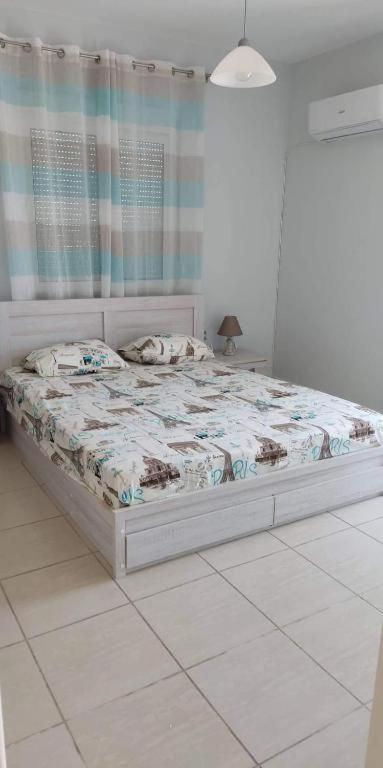 - une chambre blanche avec un lit dans l'établissement Mama Marina apartement near to the airport 2, à Antimácheia