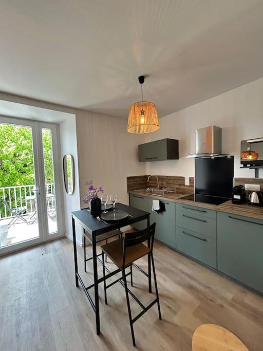 une cuisine avec une table et une salle à manger dans l'établissement Studio aux 2 terrasses, à Mirabel-et-Blacons