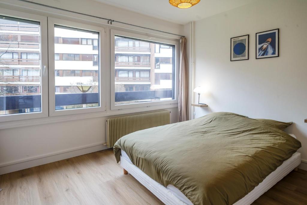 - une chambre avec un lit et 2 fenêtres dans l'établissement Grand appartement lumineux au cœur de Thonon, à Thonon-les-Bains