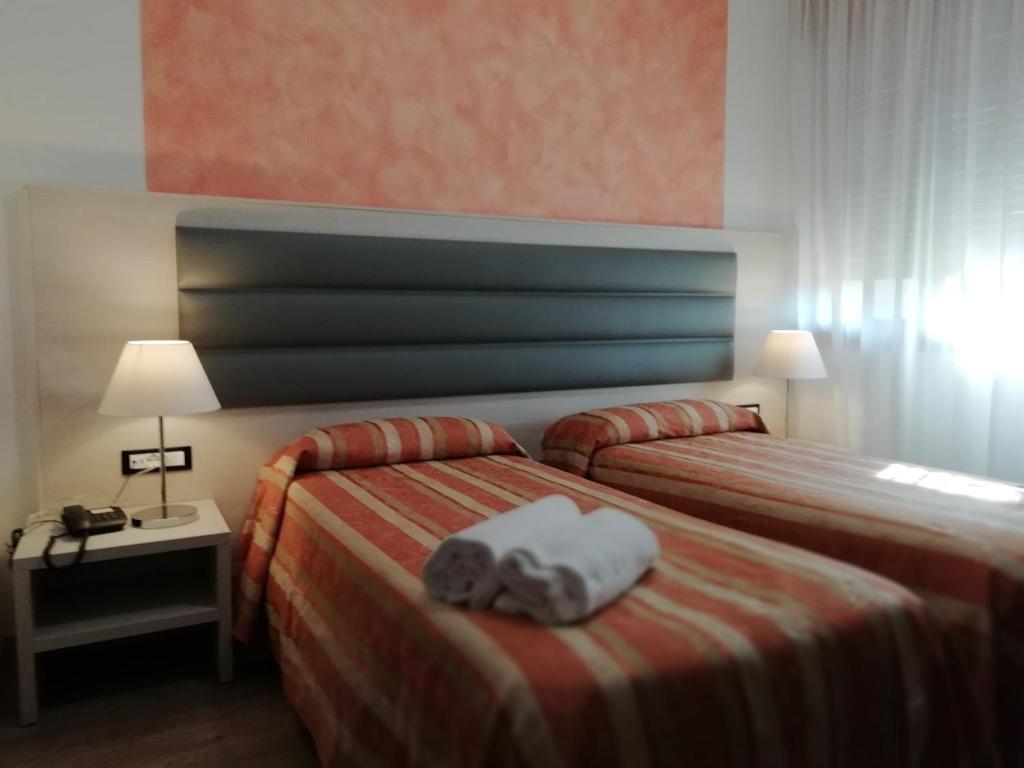 - une chambre d'hôtel avec 2 lits et des serviettes dans l'établissement Hotel Kristall, à San Donà di Piave