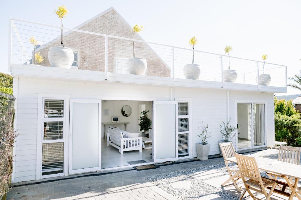 Biały dom z patio ze stołem i krzesłami w obiekcie Huis Marais w mieście Herolds Bay