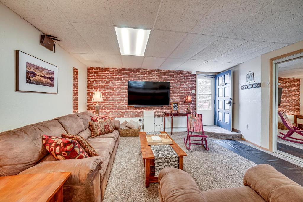 a living room with a couch and a brick wall at Cozy Apartment Less Than 4 Miles to Downtown Anchorage! in Anchorage
