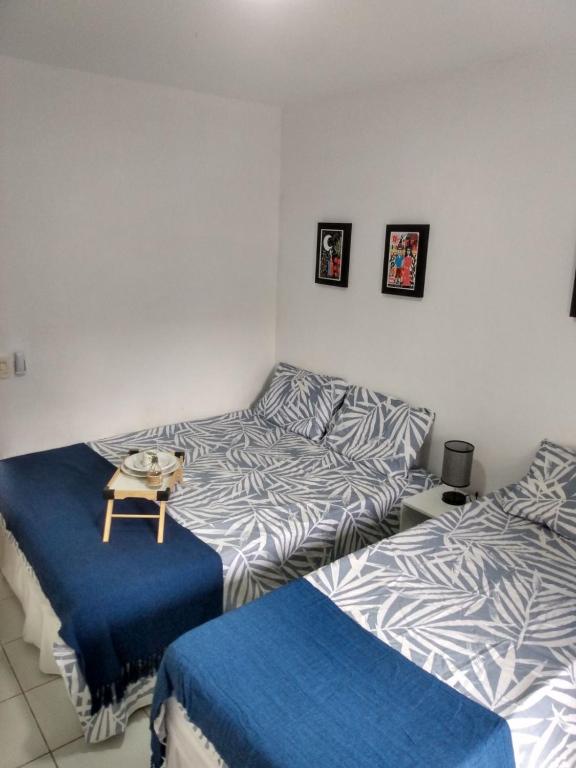 a bedroom with two beds and a table in it at Monte Castelo in Bezerros