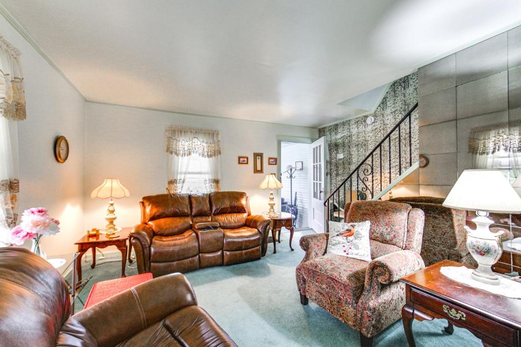 a living room with leather furniture and a staircase at Charming West Mifflin House - 3 Mi to Kennywood! in West Mifflin