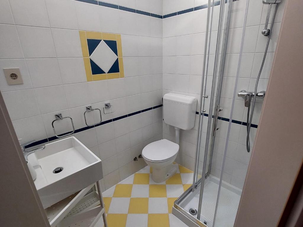 a bathroom with a shower and a toilet and a sink at Apartaments Victoria in Poreč