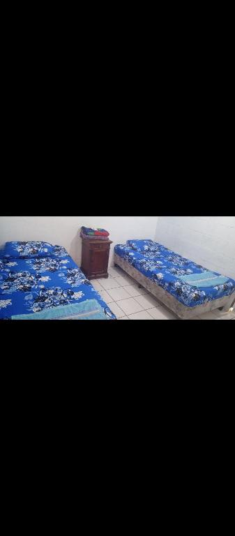 two beds sitting next to each other in a room at Mini casa a dos cuadras de la playa, en medio del comercio local in La Libertad