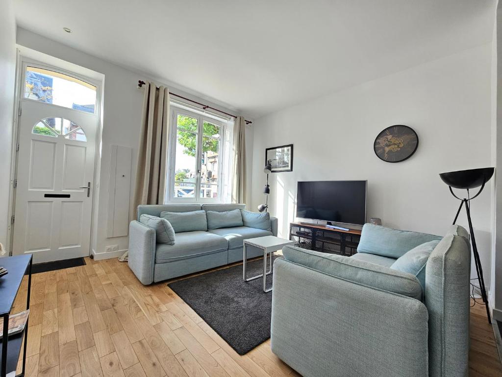 un salon avec deux canapés et une télévision dans l'établissement Maison plein centre de Deauville, à Deauville