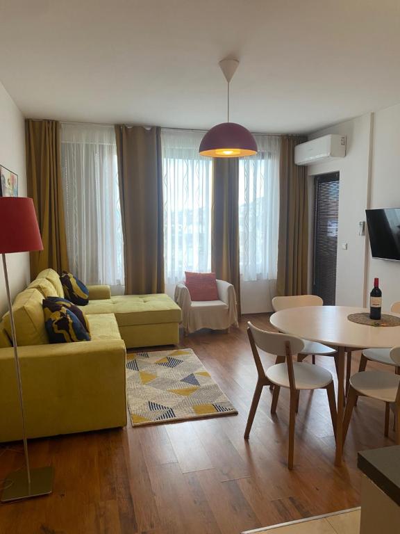 un salon avec un canapé jaune et une table dans l'établissement Neon Gondola apartment, à Bansko
