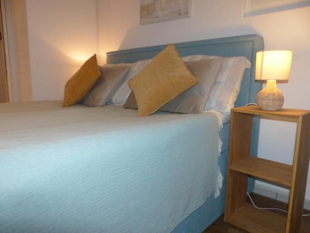 ein Bett mit zwei Kissen und einer Lampe auf einem Tisch in der Unterkunft Sweet Home in Murten