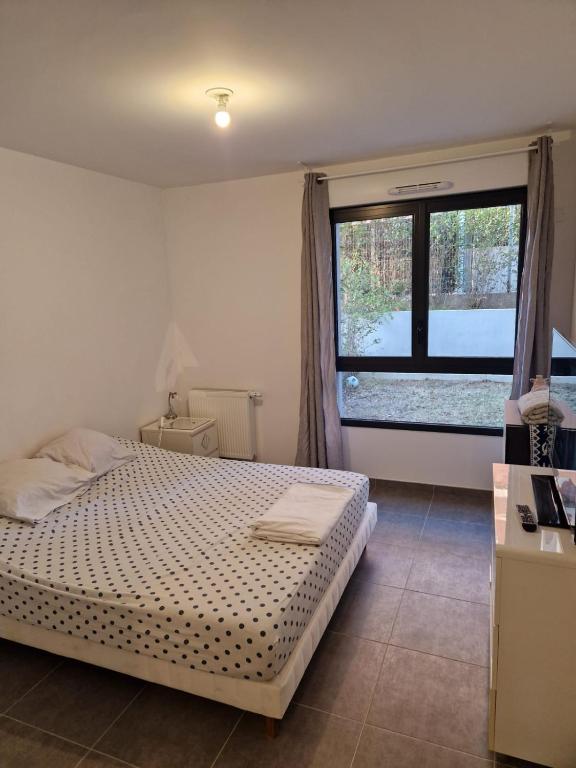 une chambre avec un lit et une grande fenêtre dans l'établissement T2 stade vélodrome, à Marseille