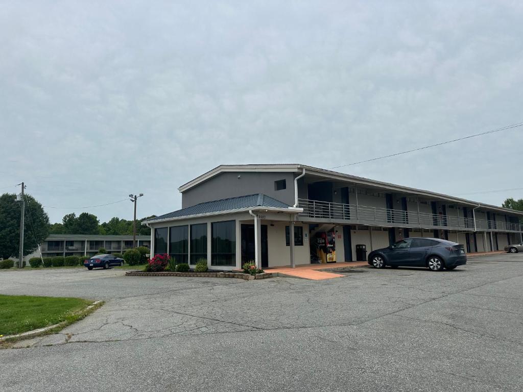 um edifício com um carro estacionado num parque de estacionamento em Bravo Inn Greensboro em Greensboro