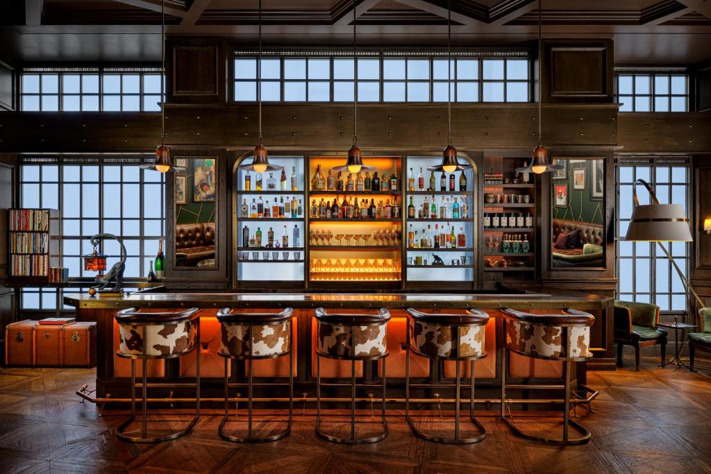 a bar with bar stools in a room with windows at Mandarin Oriental, New York in New York