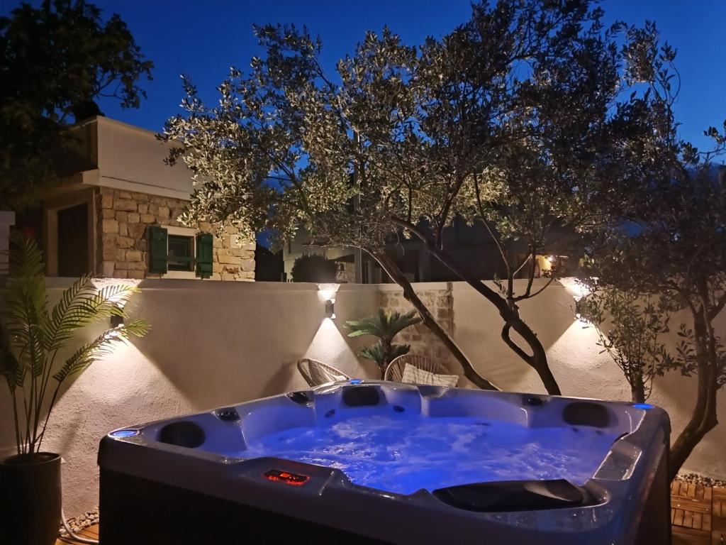 a hot tub in a yard at night at Luxury apartment Tamaris by the sea in Nin