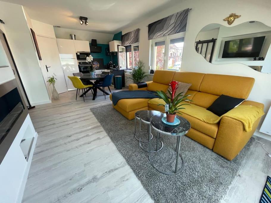 un salon avec un canapé jaune et une table dans l'établissement Résidence Belle Vue, à Boulogne-sur-Mer