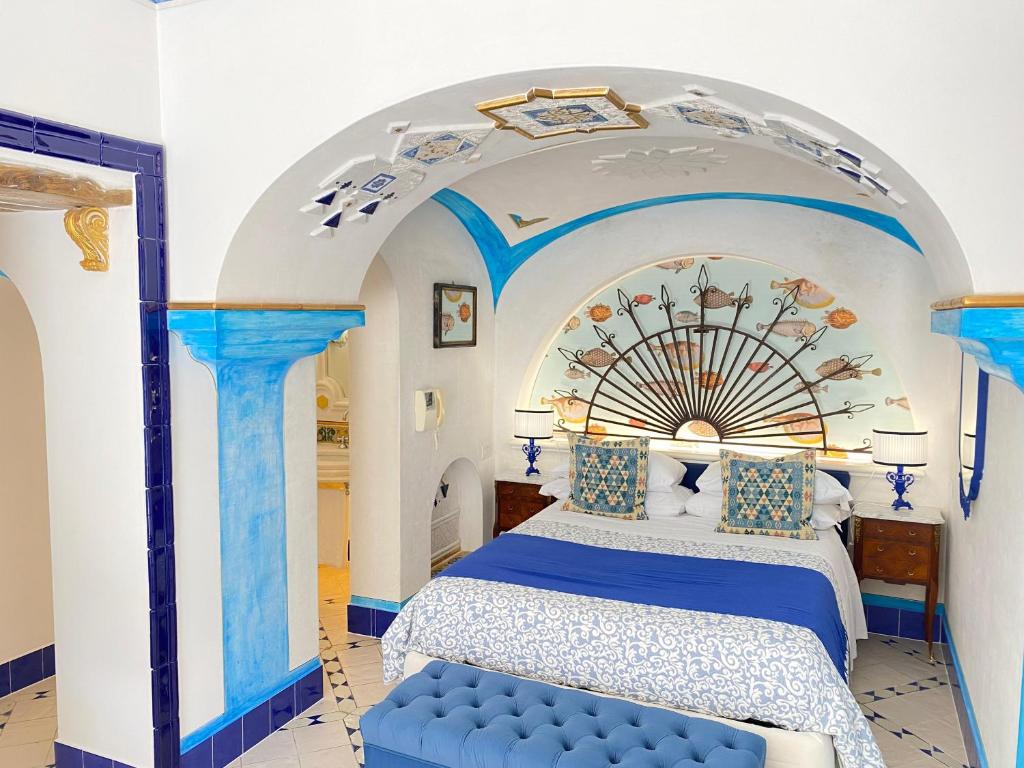 a bedroom with a blue bed and an archway at Positano Suite in Positano