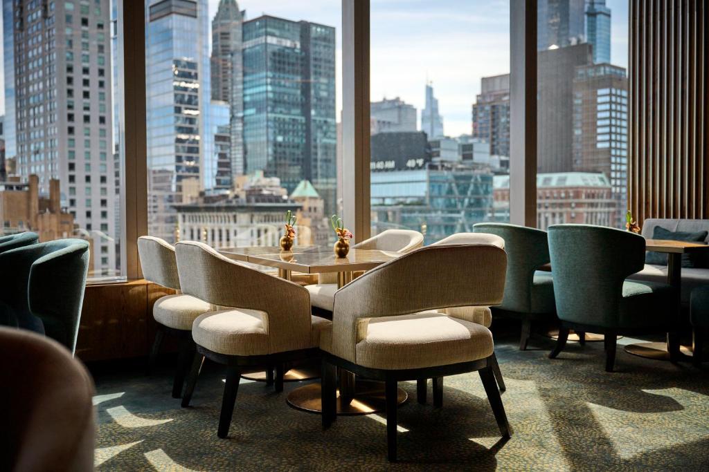 a dining room with a table and chairs and a large window at Mandarin Oriental, New York in New York