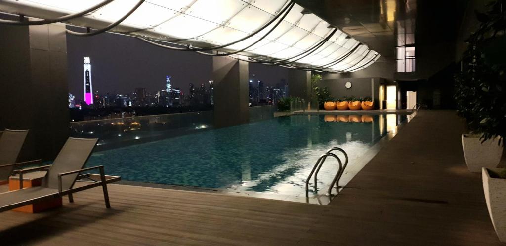 - une piscine avec vue sur la ville la nuit dans l'établissement MCity Ampang (Room in shared apartment), à Kuala Lumpur