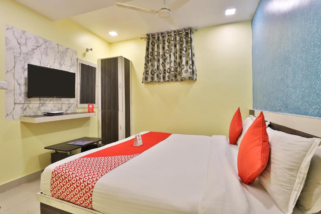 a bedroom with a large bed with red pillows at Hotel Green Land in Ahmedabad
