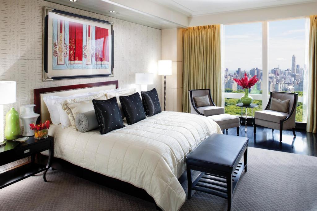 a bedroom with a large bed and a large window at Mandarin Oriental, New York in New York