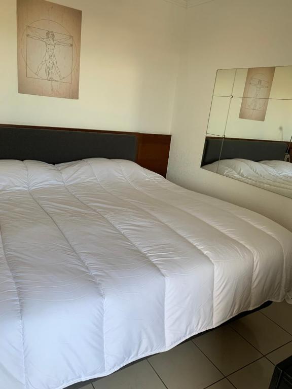 a large white bed in a bedroom with a mirror at Droit au but!! in Marseille