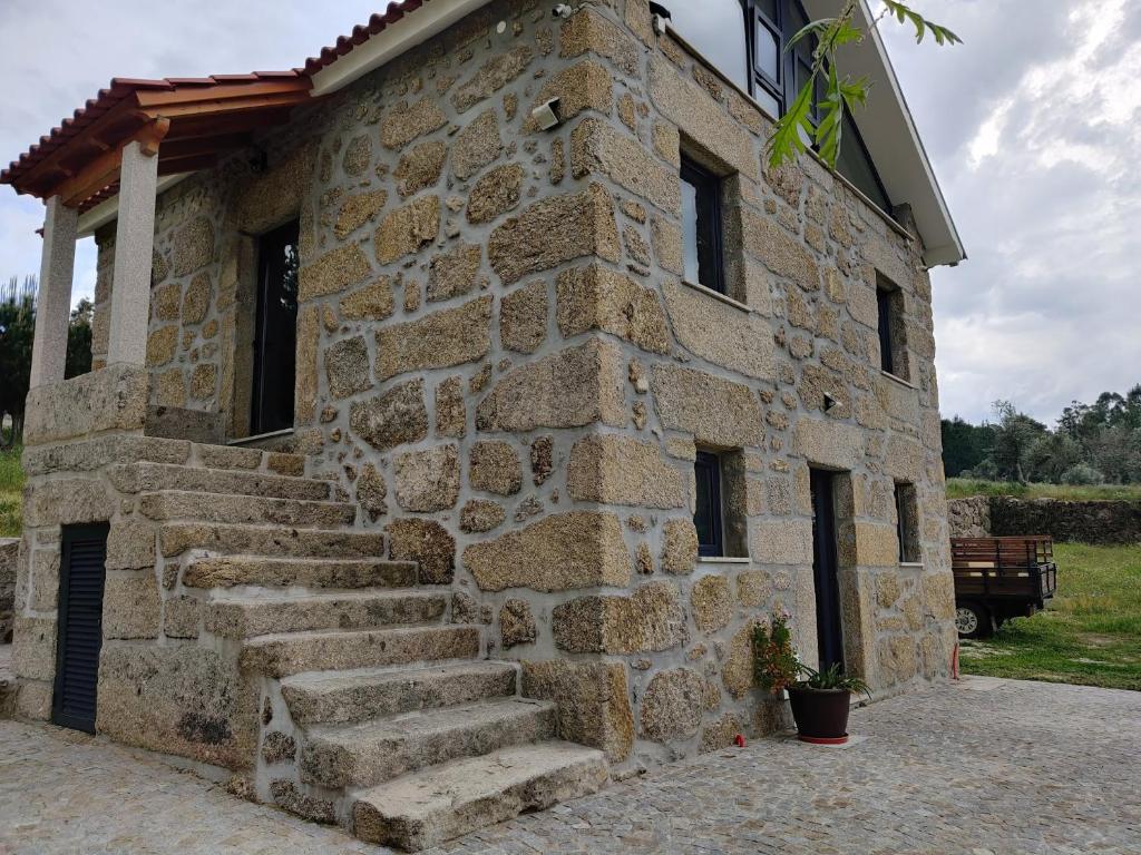 een stenen gebouw met een trap ervoor bij Arpuro in Gouveia
