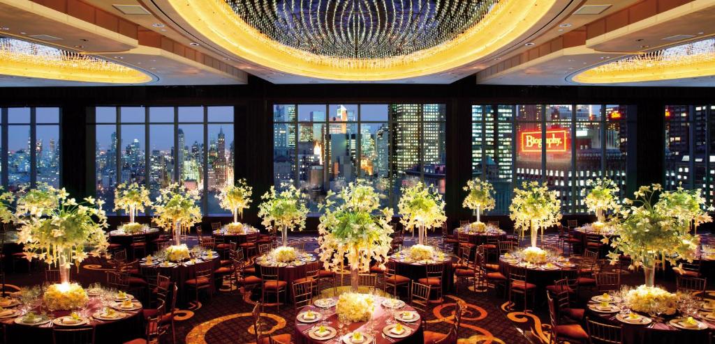 a dining room with tables and chairs and a large window at Mandarin Oriental, New York in New York