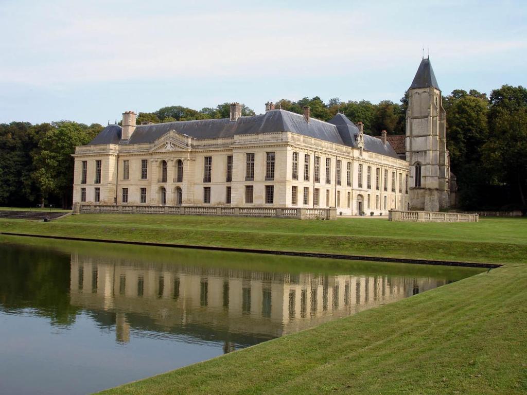 un gran edificio con un estanque frente a él en cosy mery, en Méry-sur-Oise
