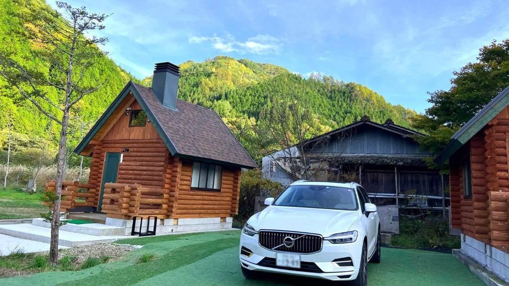 a white car parked in front of a log house at New Kurumi Land - Vacation STAY 41991v 
