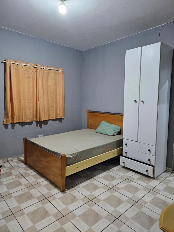 グアルーリョスにあるQUARTO ACONCHEGANTEのベッドルーム1室(ベッド1台、ドレッサー、クローゼット付)
